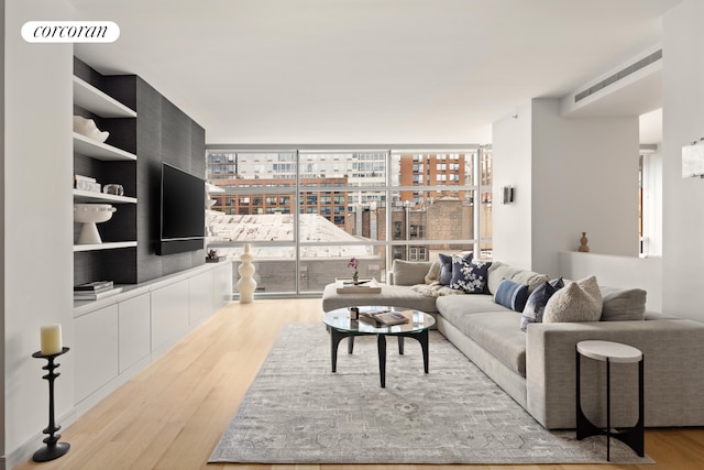 living room with expansive windows and light wood-type flooring