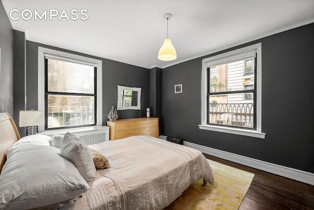 bedroom with dark hardwood / wood-style floors and ornamental molding