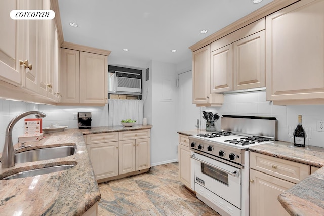 kitchen featuring light stone counters, high end stove, sink, and a wall unit AC