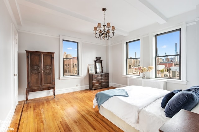 bedroom with radiator, light wood-type flooring, a chandelier, and beam ceiling