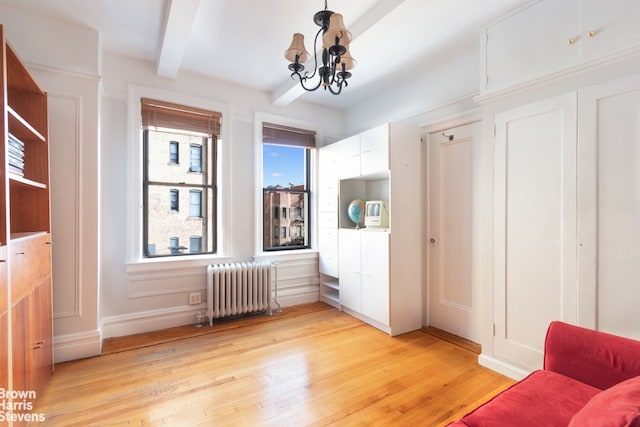 interior space featuring light wood-type flooring, beamed ceiling, radiator, and a chandelier