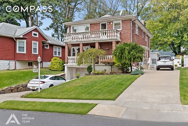 view of front facade featuring a balcony and a front lawn