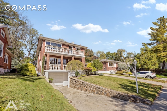 view of front property featuring a front lawn, a garage, and a balcony