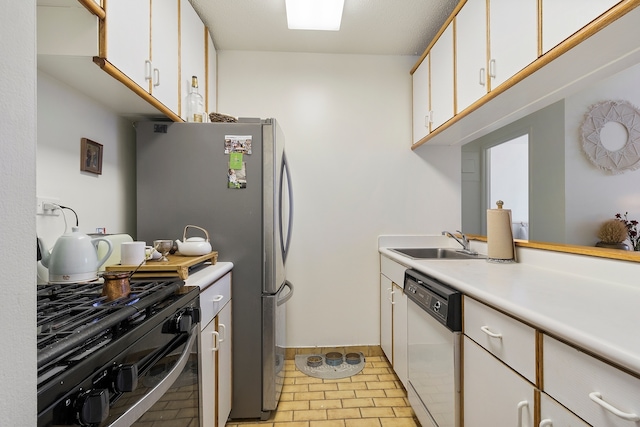 kitchen featuring dishwasher, sink, white cabinetry, black range with gas cooktop, and stainless steel refrigerator