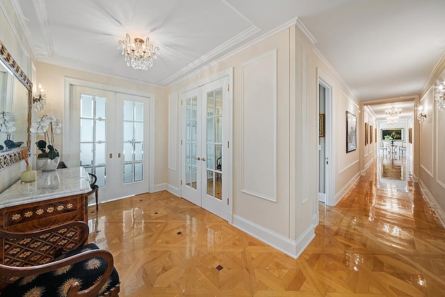 doorway with light parquet floors, an inviting chandelier, crown molding, and french doors