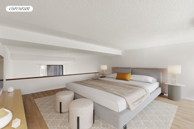 bedroom featuring light hardwood / wood-style flooring and a textured ceiling