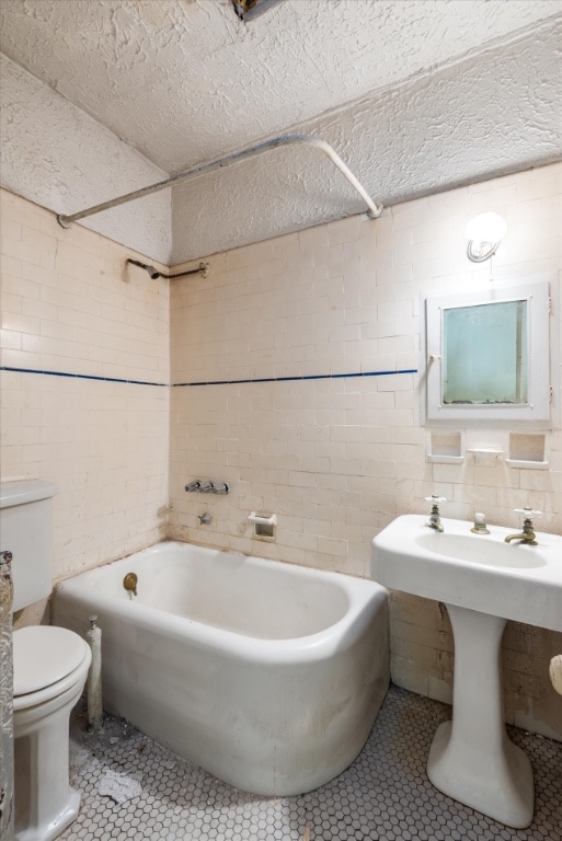 bathroom featuring tile patterned flooring, toilet, and shower / washtub combination