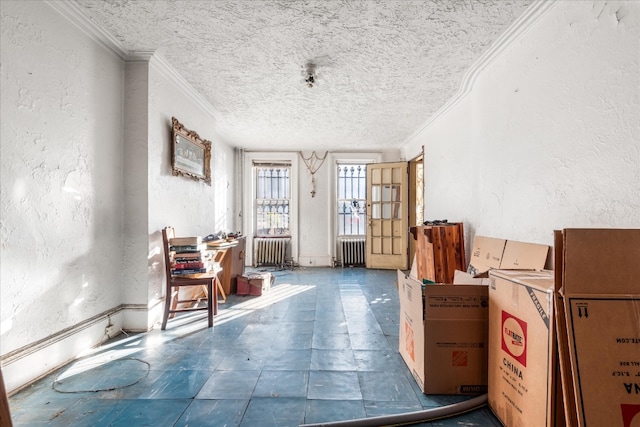 misc room with a textured ceiling, radiator, and crown molding