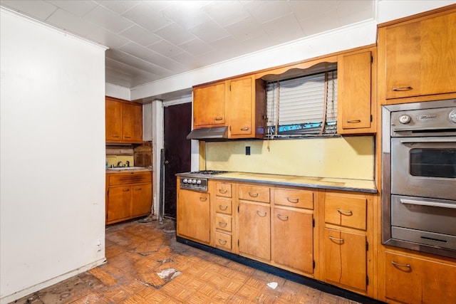 kitchen featuring sink, light parquet flooring, ornamental molding, and appliances with stainless steel finishes