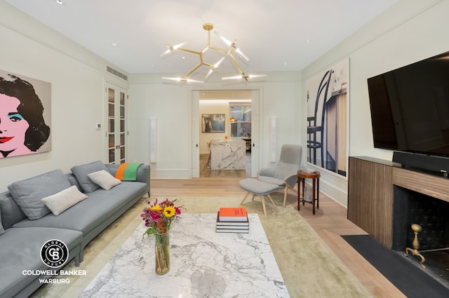 living room with a chandelier and light hardwood / wood-style floors