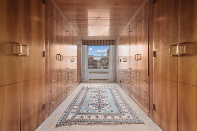 hallway featuring wood walls