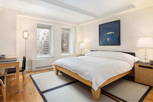 bedroom featuring light hardwood / wood-style floors, crown molding, and beam ceiling