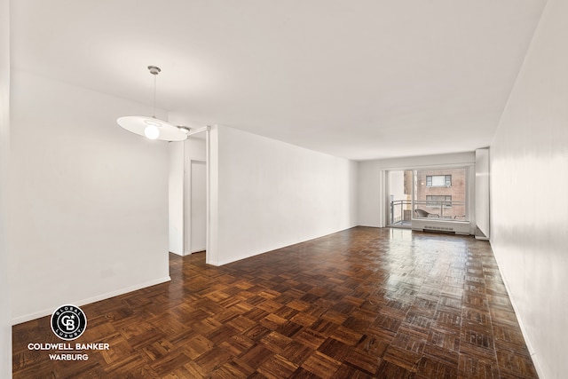 spare room featuring dark parquet flooring