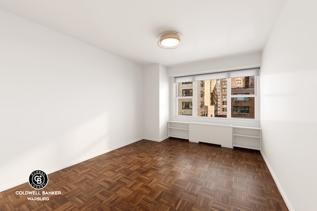 spare room with dark parquet flooring