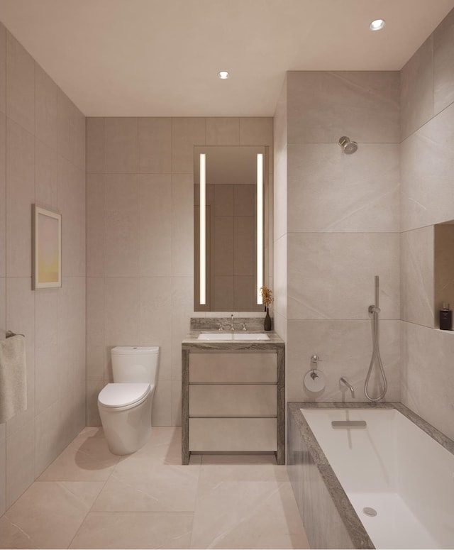 bathroom featuring tile patterned flooring, tiled tub, toilet, vanity, and tile walls