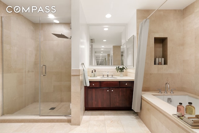 bathroom featuring tile walls, vanity, and plus walk in shower