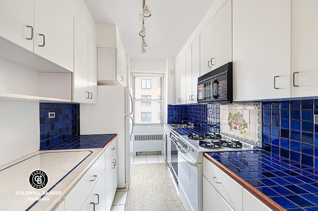 kitchen with tile counters, light tile patterned floors, white cabinetry, white appliances, and tasteful backsplash