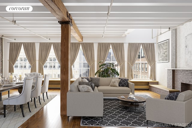 living room with hardwood / wood-style flooring, a fireplace, beam ceiling, and a healthy amount of sunlight