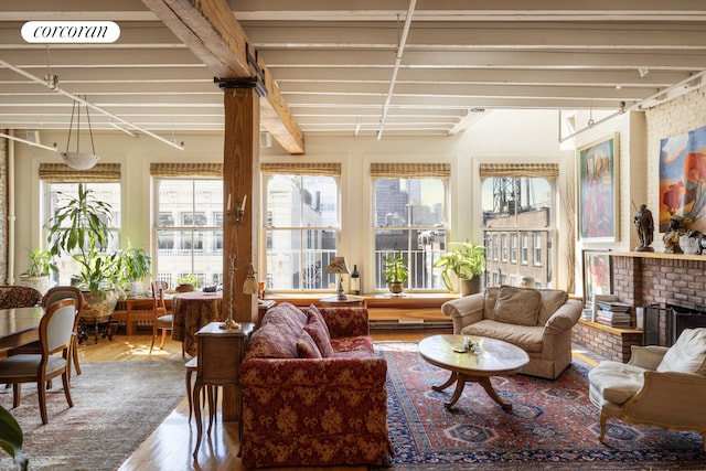 sunroom featuring a brick fireplace and plenty of natural light