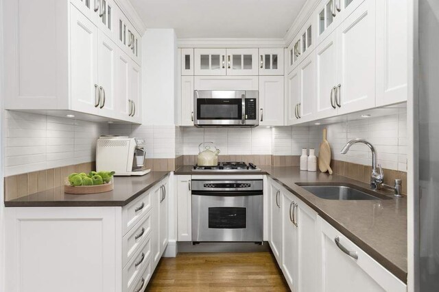 kitchen featuring hardwood / wood-style flooring, sink, white cabinetry, and stainless steel appliances