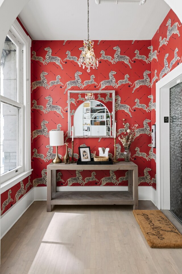 sitting room featuring a notable chandelier, wood-type flooring, and elevator