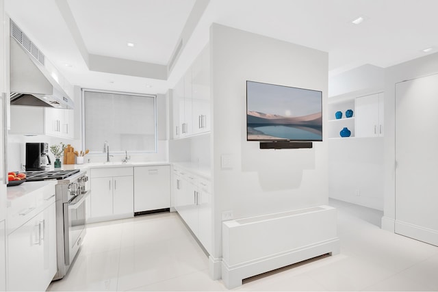 kitchen with wall chimney range hood, white cabinets, light tile patterned floors, high end stainless steel range oven, and white dishwasher