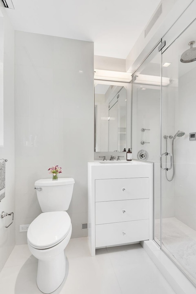 bathroom with vanity, tile patterned floors, toilet, and an enclosed shower