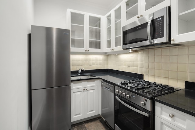 kitchen featuring backsplash, appliances with stainless steel finishes, sink, and white cabinetry