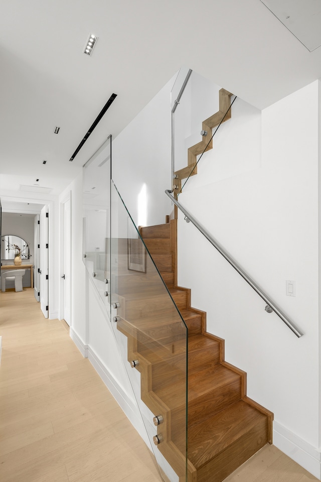 staircase with hardwood / wood-style flooring