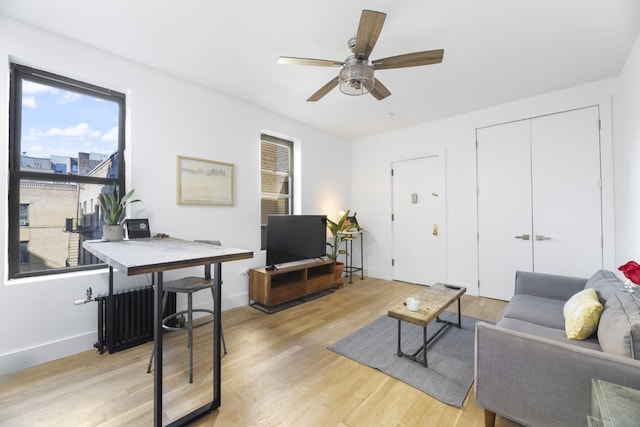 living room with ceiling fan and light wood-type flooring