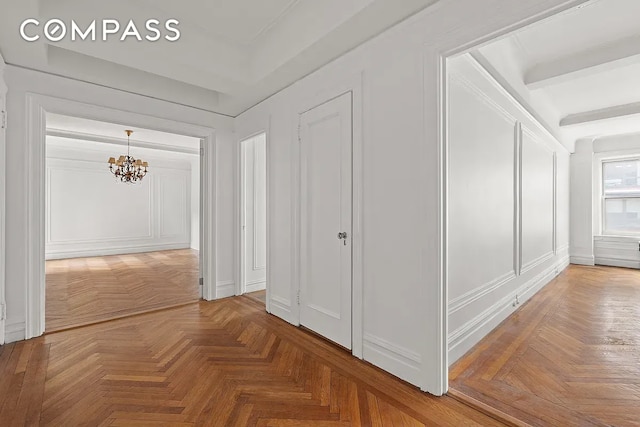 hall with parquet flooring and a notable chandelier