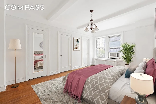 bedroom with beamed ceiling, hardwood / wood-style floors, cooling unit, and a notable chandelier