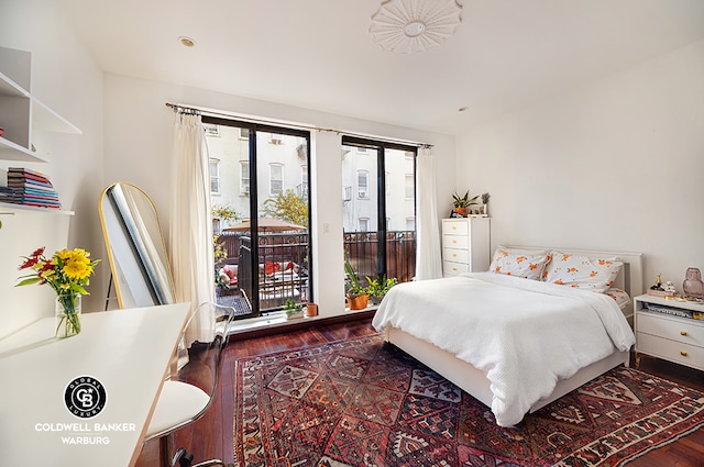 bedroom featuring access to outside, multiple windows, and hardwood / wood-style flooring