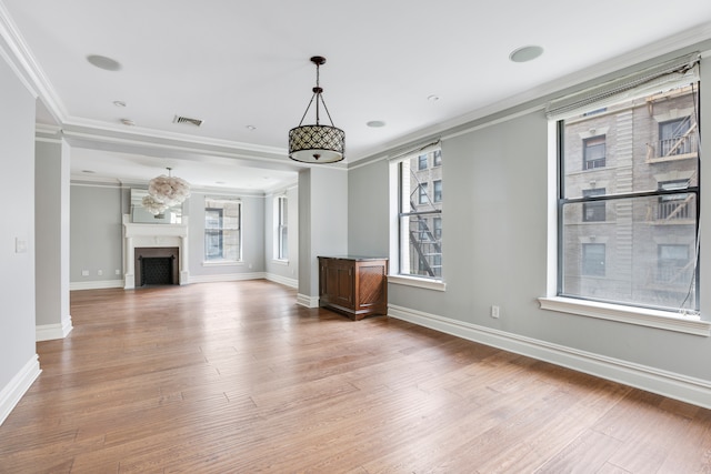 unfurnished living room with ornamental molding and hardwood / wood-style flooring