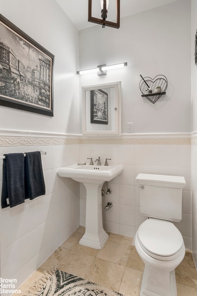 bathroom with tile walls, toilet, and tile patterned flooring