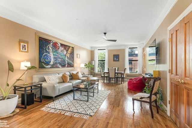 living room with hardwood / wood-style floors, crown molding, and ceiling fan