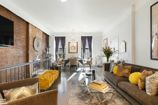 living room featuring crown molding, hardwood / wood-style flooring, and brick wall