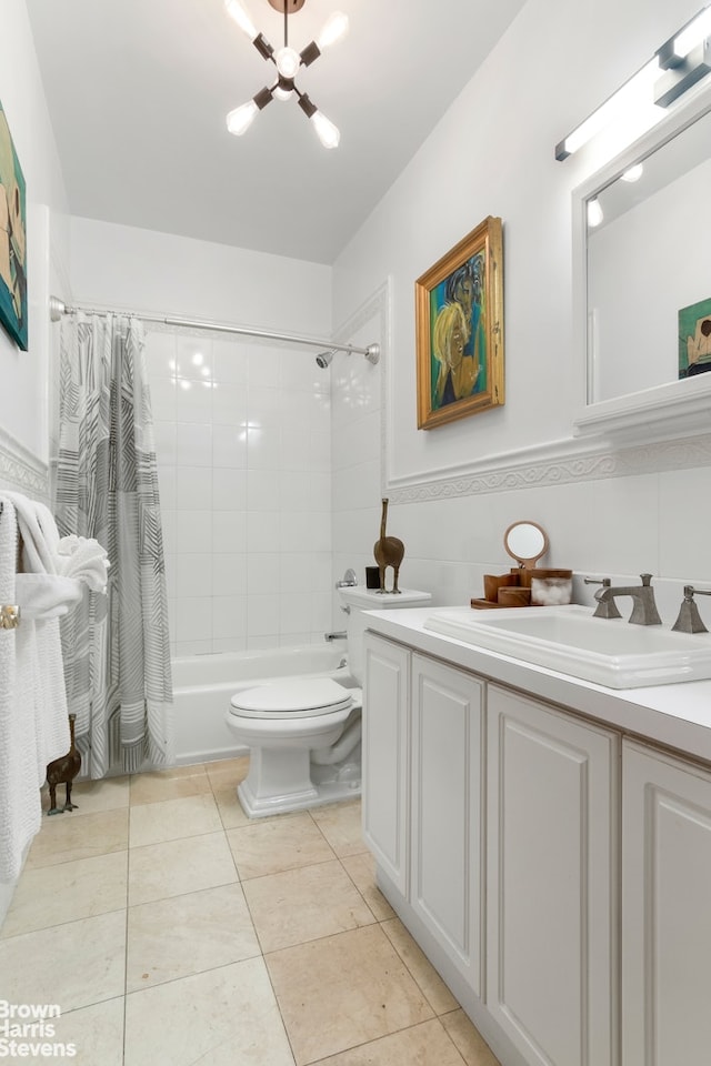 full bathroom with toilet, tile patterned floors, shower / bath combo with shower curtain, vanity, and an inviting chandelier