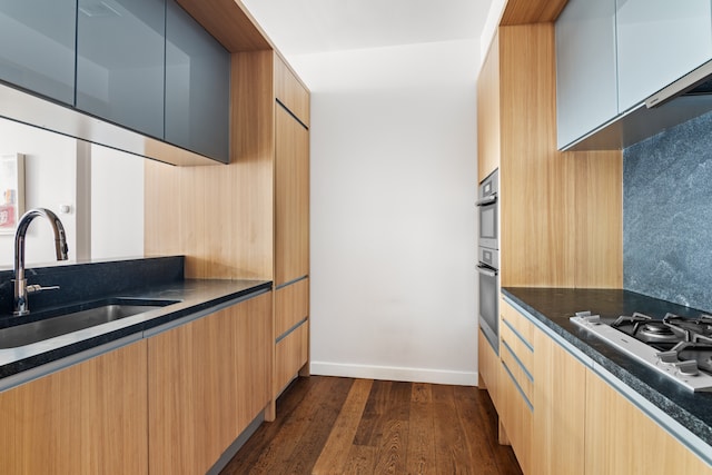 kitchen with white gas stovetop, dark hardwood / wood-style floors, sink, and dark stone counters