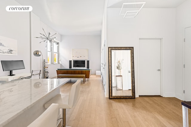 kitchen with a breakfast bar, light stone countertops, and light wood-type flooring