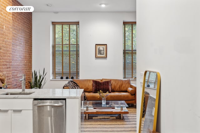 living room with sink, brick wall, and a wealth of natural light