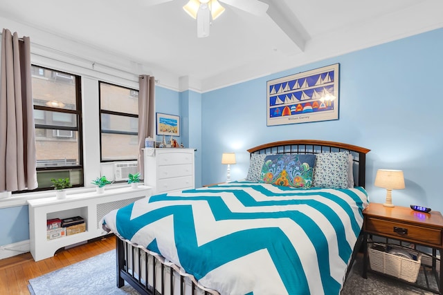 bedroom featuring ceiling fan, cooling unit, and hardwood / wood-style floors