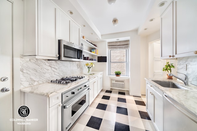 kitchen featuring tasteful backsplash, appliances with stainless steel finishes, sink, and white cabinets