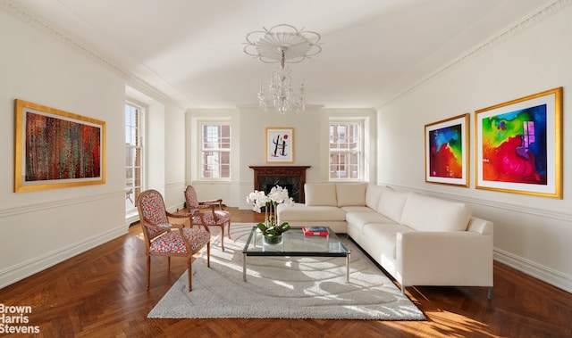 living room with parquet flooring, a fireplace, crown molding, and a notable chandelier