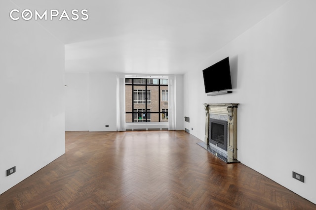 unfurnished living room featuring dark parquet floors