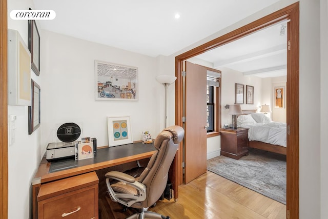 office with beam ceiling and light hardwood / wood-style flooring