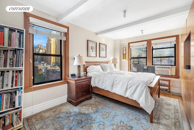 bedroom featuring beam ceiling, light hardwood / wood-style flooring, and cooling unit