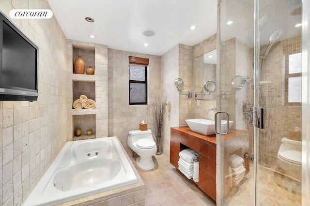 full bathroom featuring vanity, toilet, tile walls, and separate shower and tub