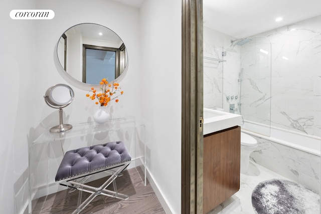 bathroom with vanity, tiled shower, and toilet