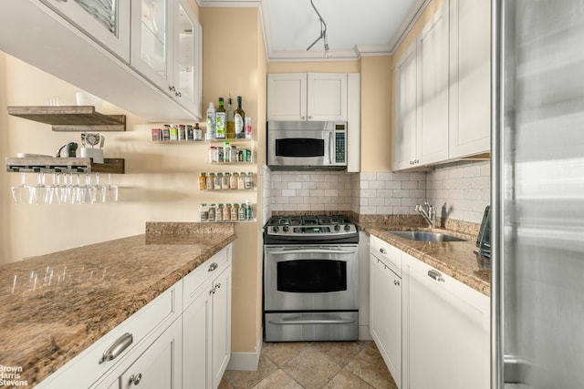 kitchen featuring dark stone countertops, appliances with stainless steel finishes, sink, and white cabinets